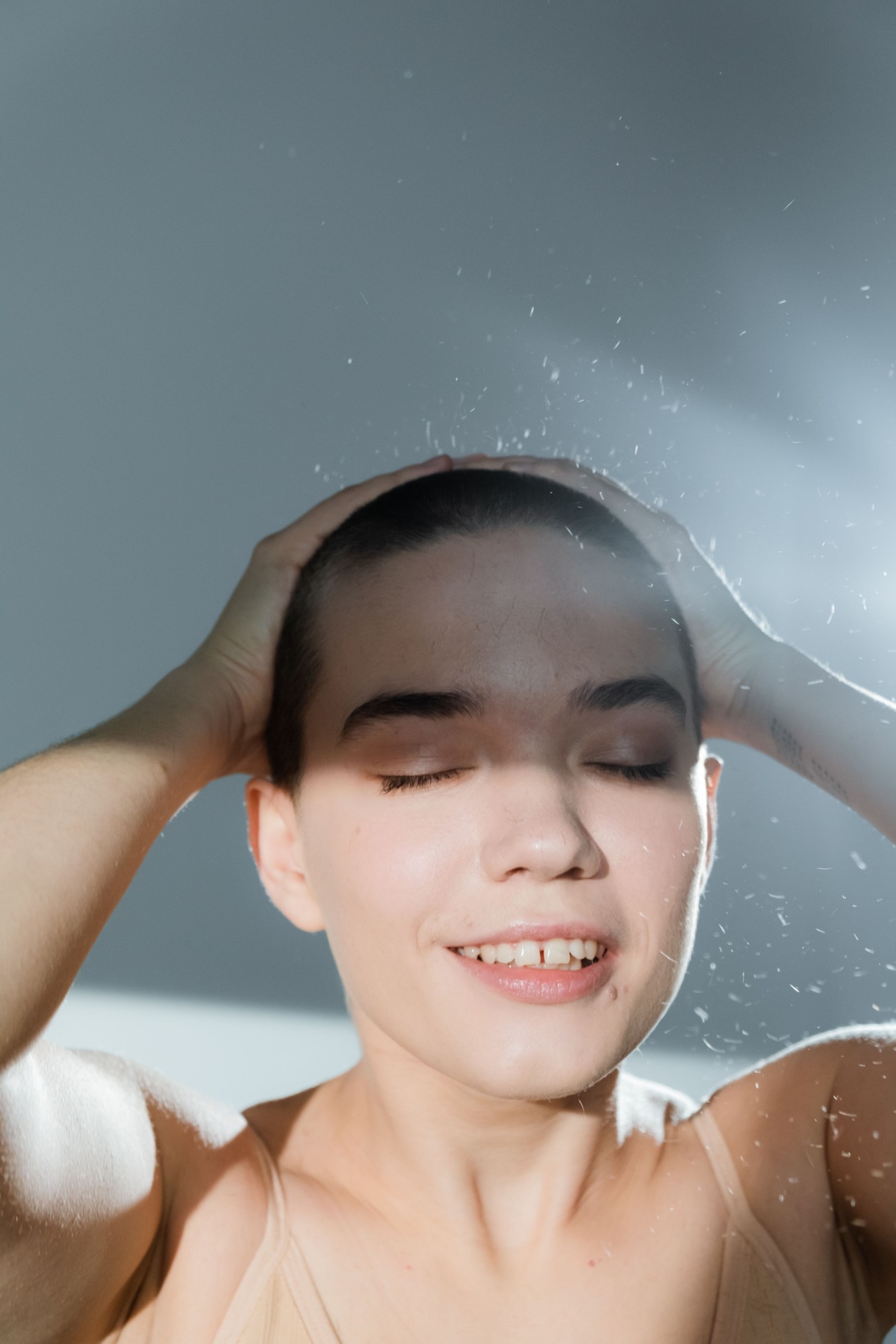 Woman rinsing her scalp in the shower